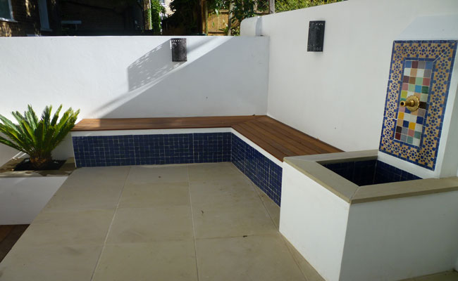Landscape gardeners, North London design patio and garden bench with water feature.